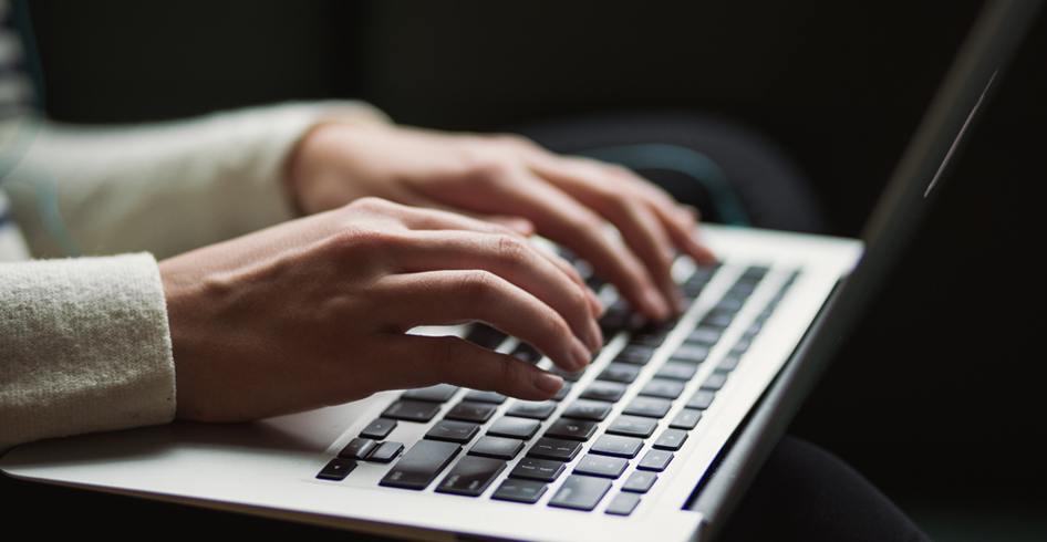 Hands typing on a laptop - a common cause of RSI